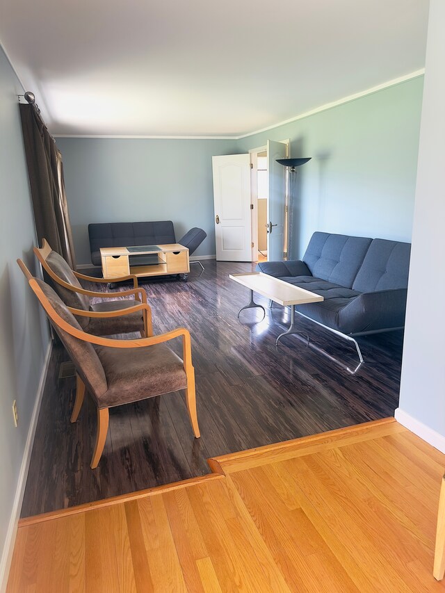 living area featuring baseboards and wood finished floors
