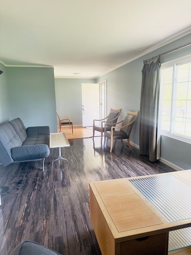 living room with crown molding, baseboards, and wood finished floors