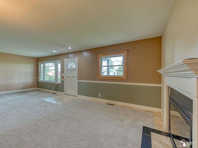 entryway featuring visible vents, baseboards, recessed lighting, light colored carpet, and a fireplace with flush hearth