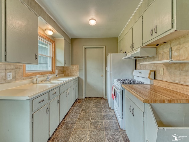 kitchen with a sink, backsplash, white range with gas cooktop, and under cabinet range hood