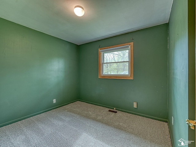 unfurnished room featuring carpet floors, baseboards, and visible vents