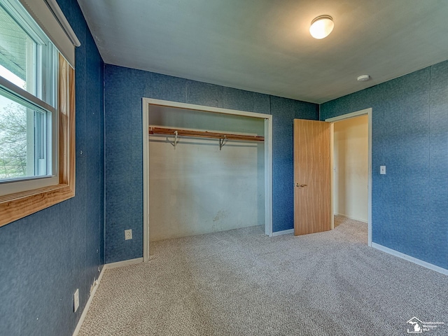 unfurnished bedroom with carpet flooring and a closet