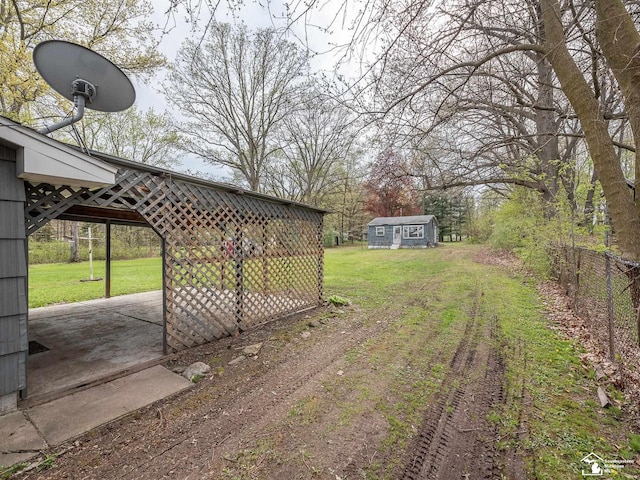 view of yard featuring fence and an outbuilding