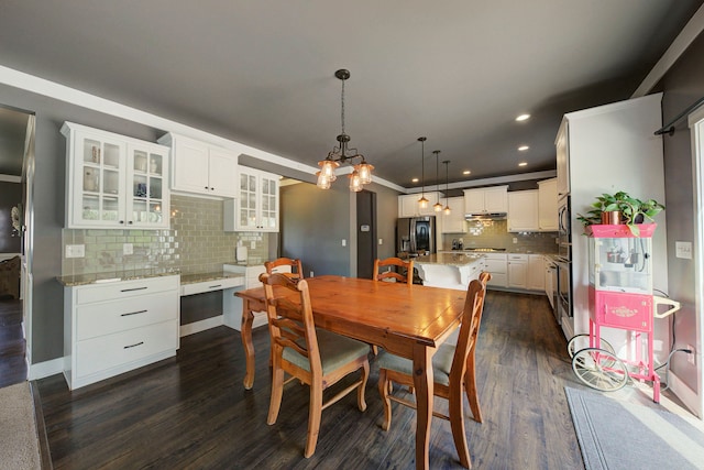 dining space with recessed lighting, dark wood finished floors, and a notable chandelier
