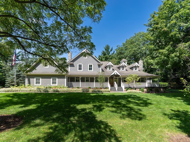 farmhouse featuring a chimney, a porch, and a front lawn
