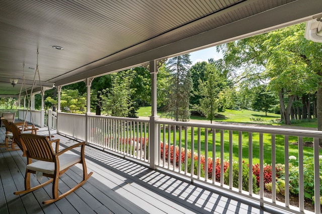 wooden terrace featuring a lawn