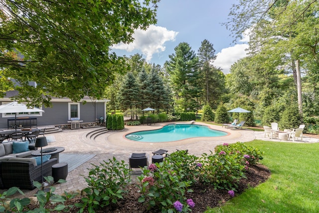 outdoor pool with fence, a patio, and a lawn