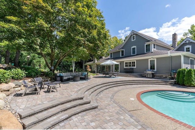 outdoor pool featuring a patio, a grill, and an outdoor living space