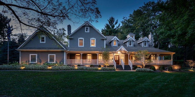 view of front of house featuring a chimney, a front lawn, and covered porch
