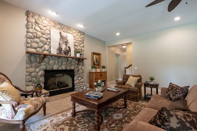 carpeted living room featuring stairway, a ceiling fan, a stone fireplace, and recessed lighting