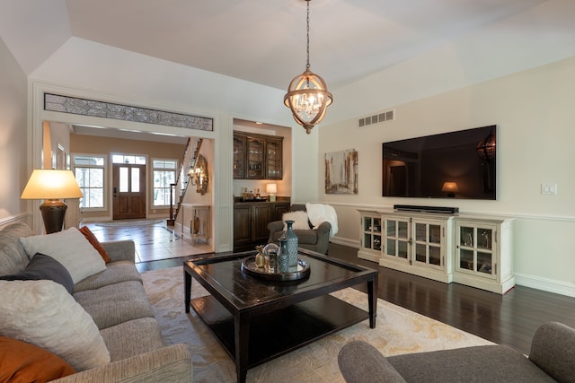 living room featuring a chandelier, baseboards, dark wood-style floors, and visible vents