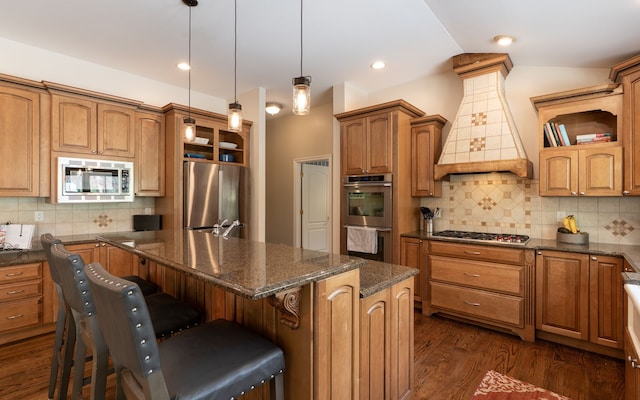 kitchen with premium range hood, dark wood-style flooring, backsplash, a center island, and appliances with stainless steel finishes