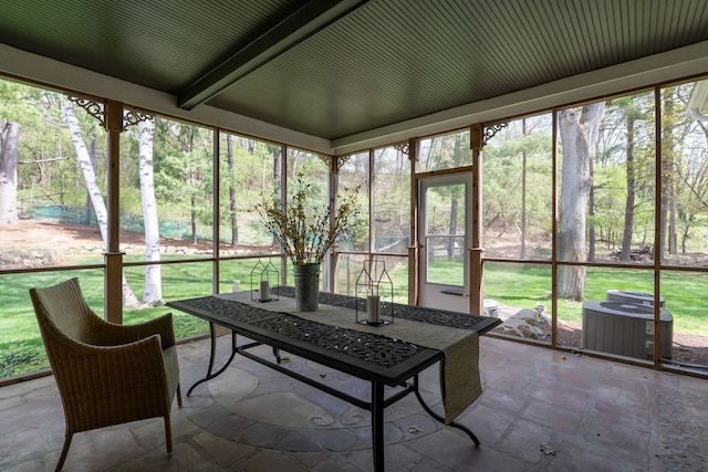 sunroom / solarium featuring beam ceiling