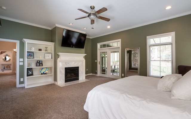 carpeted bedroom featuring multiple windows, ornamental molding, access to outside, and a fireplace