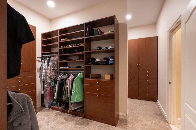 walk in closet featuring light carpet