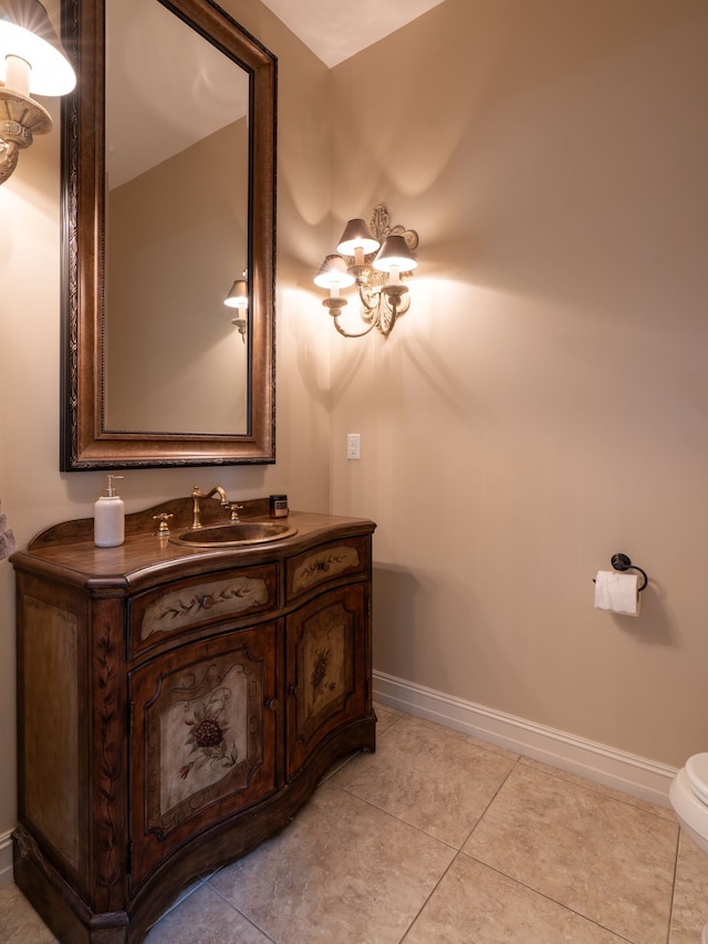 bathroom with toilet, baseboards, tile patterned flooring, a chandelier, and vanity