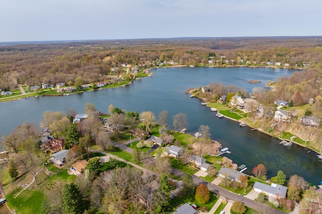 drone / aerial view featuring a residential view, a water view, and a forest view