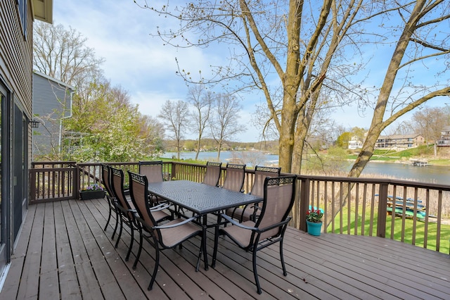 deck with outdoor dining area and a water view