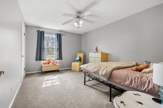 carpeted bedroom featuring baseboards, ceiling fan, and a textured ceiling