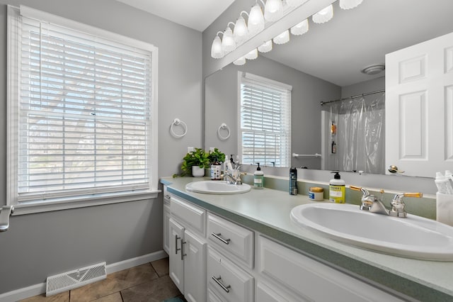 full bathroom with visible vents, a sink, baseboards, and tile patterned floors