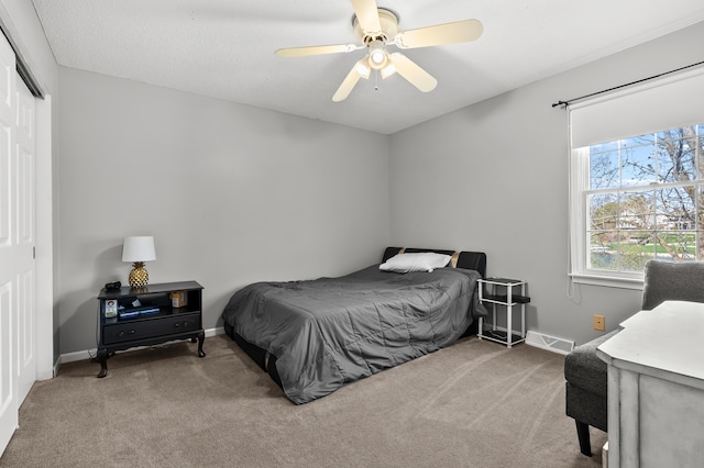 carpeted bedroom featuring a ceiling fan, baseboards, visible vents, and a closet