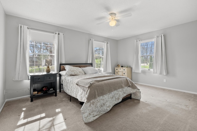 carpeted bedroom featuring baseboards and ceiling fan