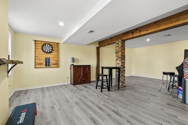 interior space featuring baseboards, wood finished floors, and visible vents