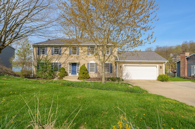 colonial house with concrete driveway, a front lawn, and a garage