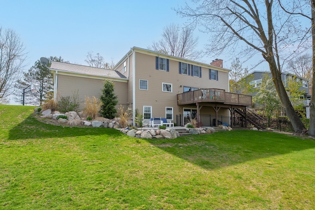 rear view of house featuring stairway, a deck, a yard, and a chimney