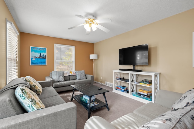 living area with visible vents, ceiling fan, and carpet floors
