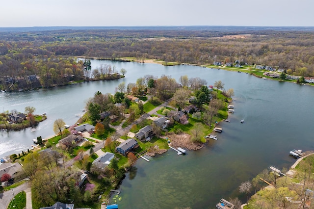 drone / aerial view featuring a water view, a residential view, and a wooded view