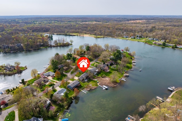 drone / aerial view featuring a water view, a view of trees, and a residential view
