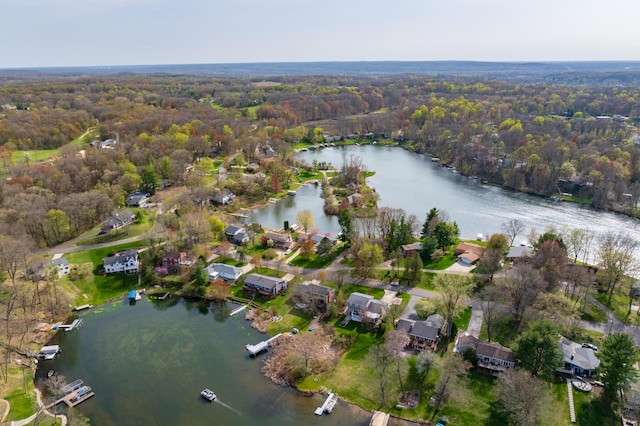 birds eye view of property with a water view, a view of trees, and a residential view
