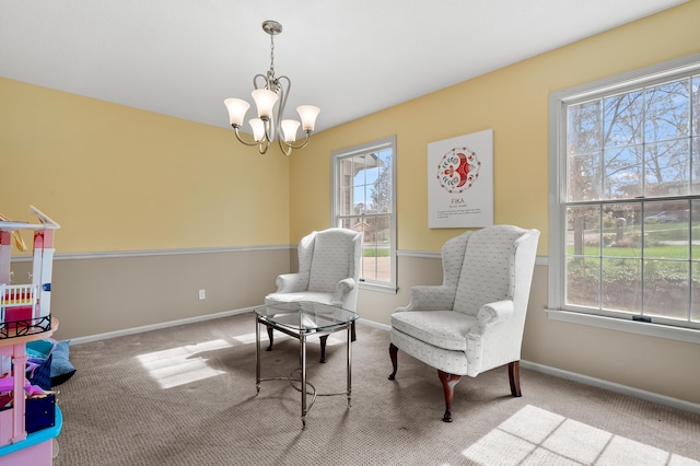 sitting room featuring an inviting chandelier, baseboards, plenty of natural light, and carpet flooring
