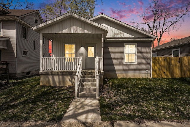 bungalow-style home featuring fence, a porch, and a front yard