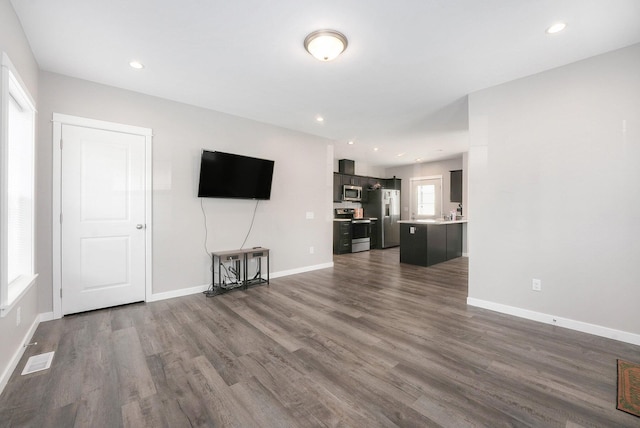 unfurnished living room with baseboards, dark wood-style floors, and visible vents