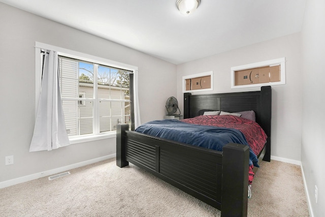 bedroom with baseboards, light carpet, and visible vents