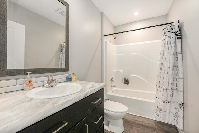 bathroom with toilet, shower / bathtub combination with curtain, wood finished floors, and vanity