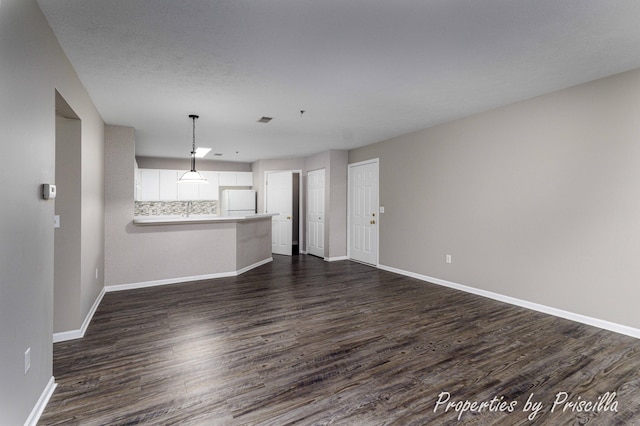 3025 Poplar Creek Dr SE Unit 104, Grand Rapids, MI 49512 - unfurnished living room with baseboards and dark wood-style floors
