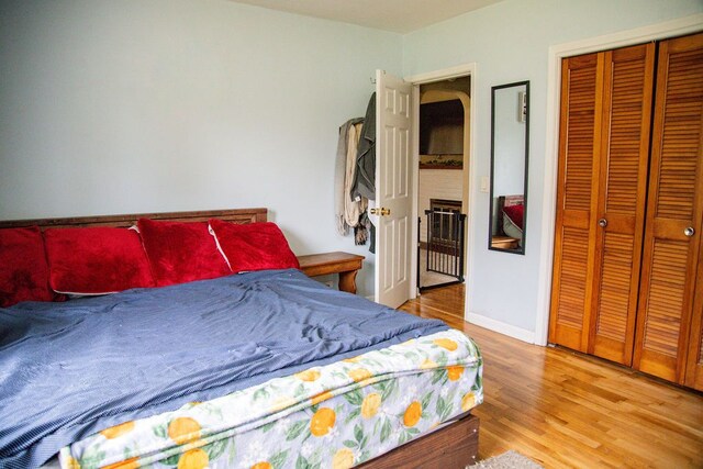 bedroom featuring light wood-style floors, baseboards, and a closet
