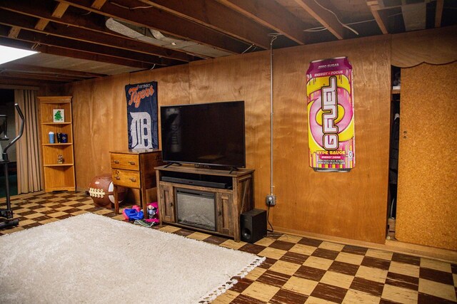 below grade area featuring wood walls, tile patterned floors, and a fireplace
