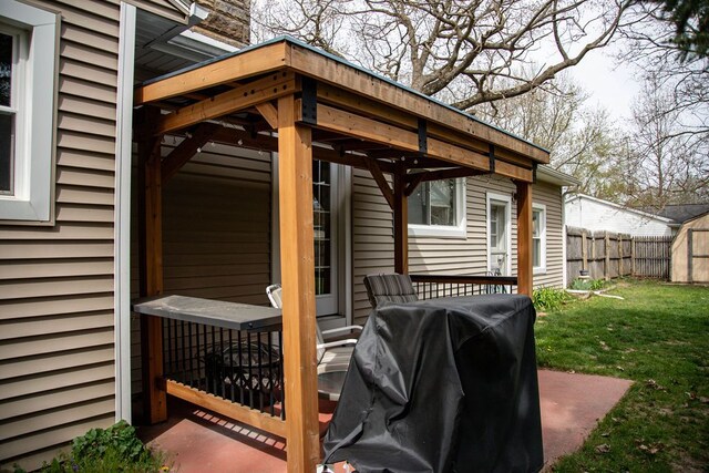 view of patio / terrace featuring grilling area, fence, an outbuilding, and a shed