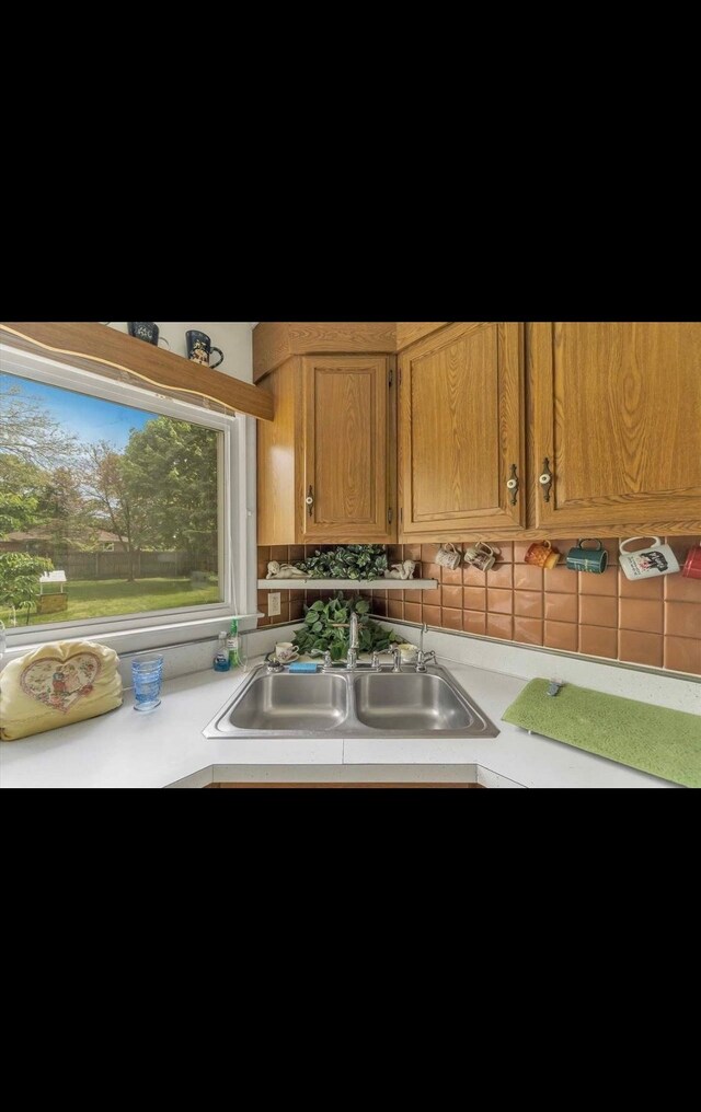 kitchen with a sink, decorative backsplash, and light countertops