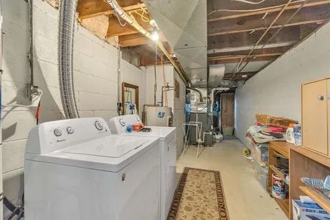 laundry area featuring laundry area, heating unit, washing machine and dryer, and water heater