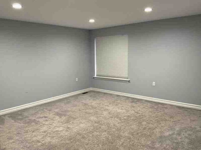 carpeted empty room with baseboards and recessed lighting