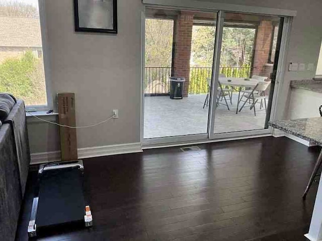 entryway with baseboards, visible vents, plenty of natural light, and wood finished floors