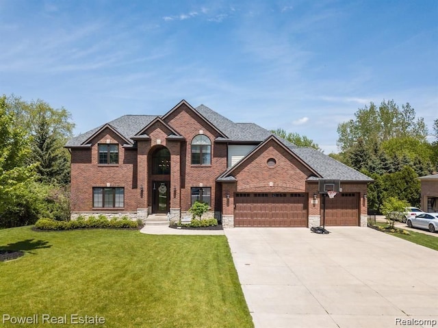 traditional home featuring concrete driveway, brick siding, an attached garage, and a front yard