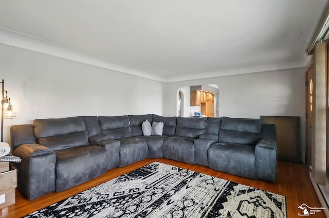 living area with arched walkways and wood finished floors