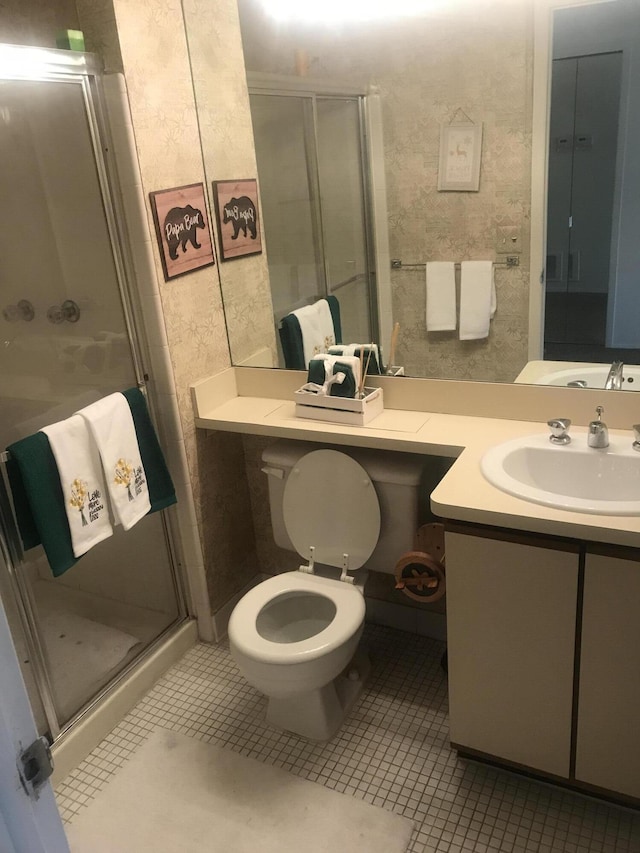 bathroom featuring tile patterned flooring, vanity, toilet, wallpapered walls, and a shower stall