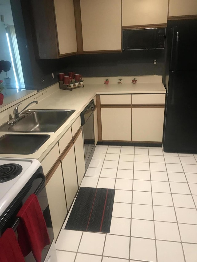 kitchen with a sink, light tile patterned floors, black appliances, and light countertops